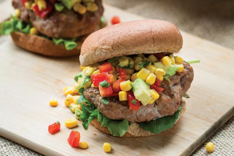 turkey burgers stacked tall with avocado, corn, and peppers